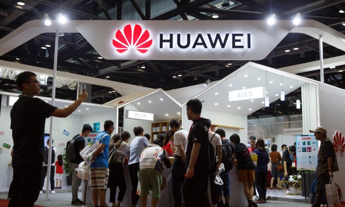 Mọi người nhìn vào các sản phẩm tại gian hàng của Huawei tại Triển lãm Điện tử Tiêu dùng Quốc tế tại Bắc Kinh, vào ngày 2 tháng 8 năm 2019. (Thomas Peter / Reuters/ qua The Epoch Times)