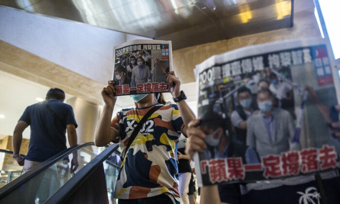 Mọi người giơ các bản sao của Apple Daily khi họ phản đối quyền tự do báo chí bên trong một trung tâm mua sắm ở Hồng Kông vào ngày 11 tháng 8 năm 2020. (ISAAC LAWRENCE / AFP / Getty Images qua The Epoch Times)