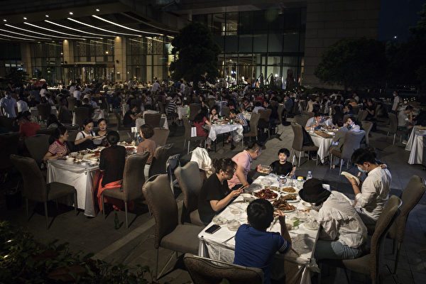 <em>Ngành dịch vụ ăn uống của Trung Quốc đã bị thiệt hại nặng nề bởi dịch bệnh viêm phổi Trung Cộng. Ảnh chụp người dân Vũ Hán dùng bữa bên ngoài khách sạn Sheraton vào ngày 28/5. Sau khi khách sạn hoạt động trở lại, doanh thu hàng ngày chỉ bằng 1/10 so với cùng thời kỳ năm ngoái. (Ảnh: Getty Images)</em>