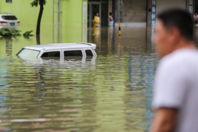 <em>Con phố ngập lụt sau trận mưa lớn đổ xuống khu vực ở Lâm Nghi, thuộc tỉnh Sơn Đông ở miền đông Trung Quốc, vào ngày 14/8/2020 (Ảnh: STR / AFP qua Getty Images)</em>