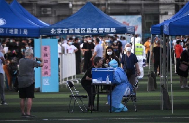 <em>Những người đã đến hoặc sống gần chợ Tân Phát Địa đang xếp hàng chờ xét nghiệm tại sân vận động Guangan ở thủ đô Bắc Kinh ngày 14/6/2020. (Ảnh: NOEL CELIS / AFP qua Getty Images)</em>
