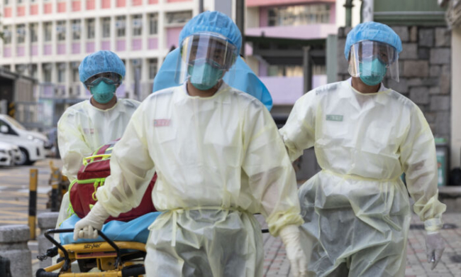 <em>Nhân viên y tế đeo thiết bị bảo hộ cá nhân phòng lây nhiễm Virus Corona Vũ Hán khi tiếp cận nhà chăm sóc Lei Muk Shue - ca đầu tiên tái nhiễm ở Hong Kong vào ngày 23/8/2020 (Ảnh: May James / May James / AFP / Getty Images)</em>