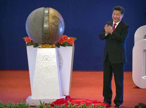 Lãnh đạo Trung Quốc Tập Cận Bình vỗ tay sau khi bỏ màn bức tượng tại lễ khai trương Ngân hàng Đầu tư Cơ sở hạ tầng châu Á (AIIB) ở Bắc Kinh vào ngày 16/1/2016. (Ảnh Mark Schiefelbein, Pool / AP)