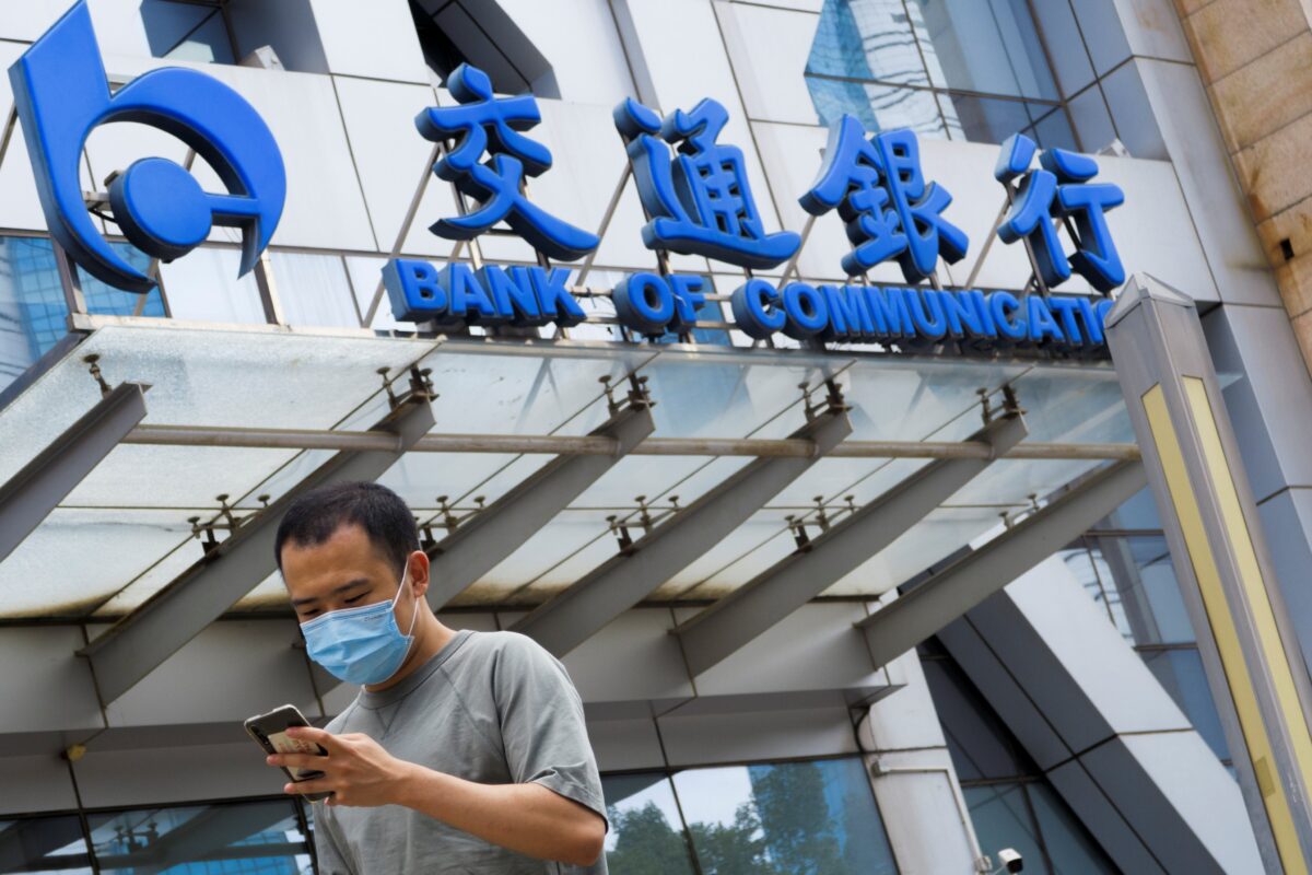 Một người đàn ông đi ngang qua văn phòng của Ngân hàng Bank of Communications ở Bắc Kinh, Trung Quốc, ngày 27/8/2020. (Ảnh Thomas Peter / Reuters)