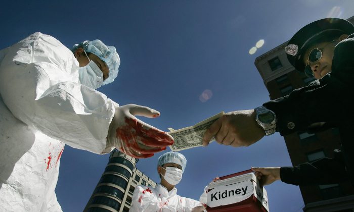 Các nhà hoạt động Trung Quốc mô phỏng lại hành vi trả tiền mua nội tạng người trong cuộc mít tinh ngày 19/4/2006, ở Washington, D.C. (Ảnh Jim Watson / AFP / Getty Images)