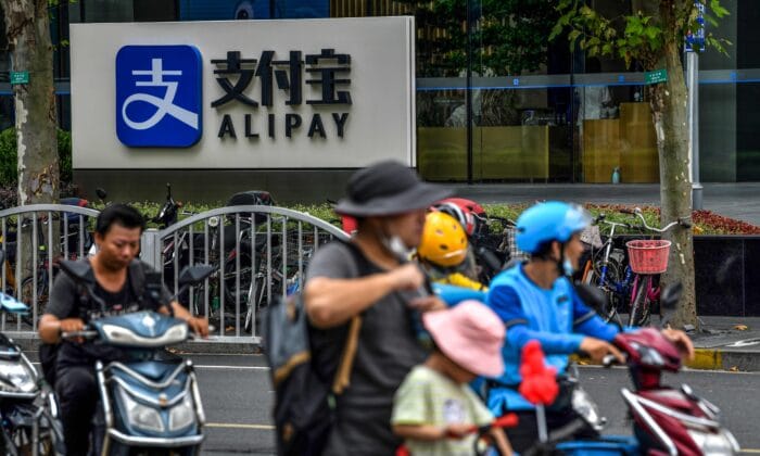 Những người lái xe ngang qua logo Alipay bên cạnh tòa nhà văn phòng Thượng Hải của Ant Group ngày 28 tháng 8 năm 2020. (Ảnh Hector Retamal/ AFP qua Getty Images)