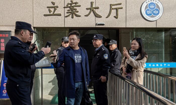Luật sư Tạ Dương (Xie Yang, ở giữa) đi cùng với thân chủ Xu Yan (phải), vợ của luật sư nhân quyền Yu Wensheng, đang cố gắng gặp trực tiếp Yu bên ngoài Tòa án Trung cấp Từ Châu ở Từ Châu, tỉnh Giang Tô, miền đông Trung Quốc vào ngày 31 tháng 10 năm 2019. ( Ảnh: Nicolas Asfouri/ AFP /Getty qua The Epoch Times)