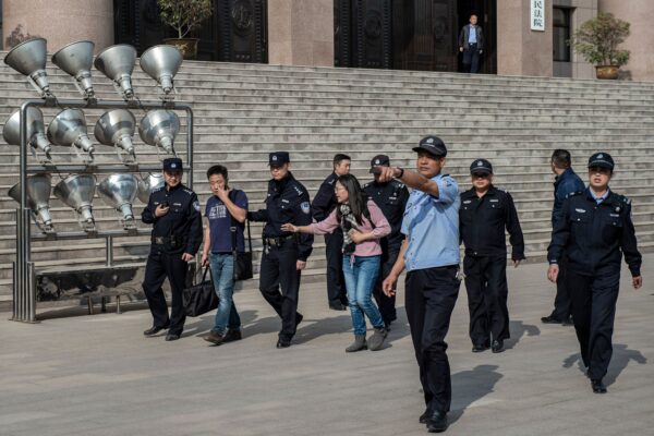 Nhân viên an ninh của Tòa án Nhân dân Trung cấp Từ Châu, Trung Quốc hộ tống Xu Yan (giữa) - vợ của luật sư nhân quyền Yu Wensheng, và luật sư Xie Yang (Tạ Dương) ra khỏi tòa án vào ngày 31 tháng 10 năm 2019. ( Ảnh: Nicolas Asfouri/AFP /Getty qua The Epoch Times)
