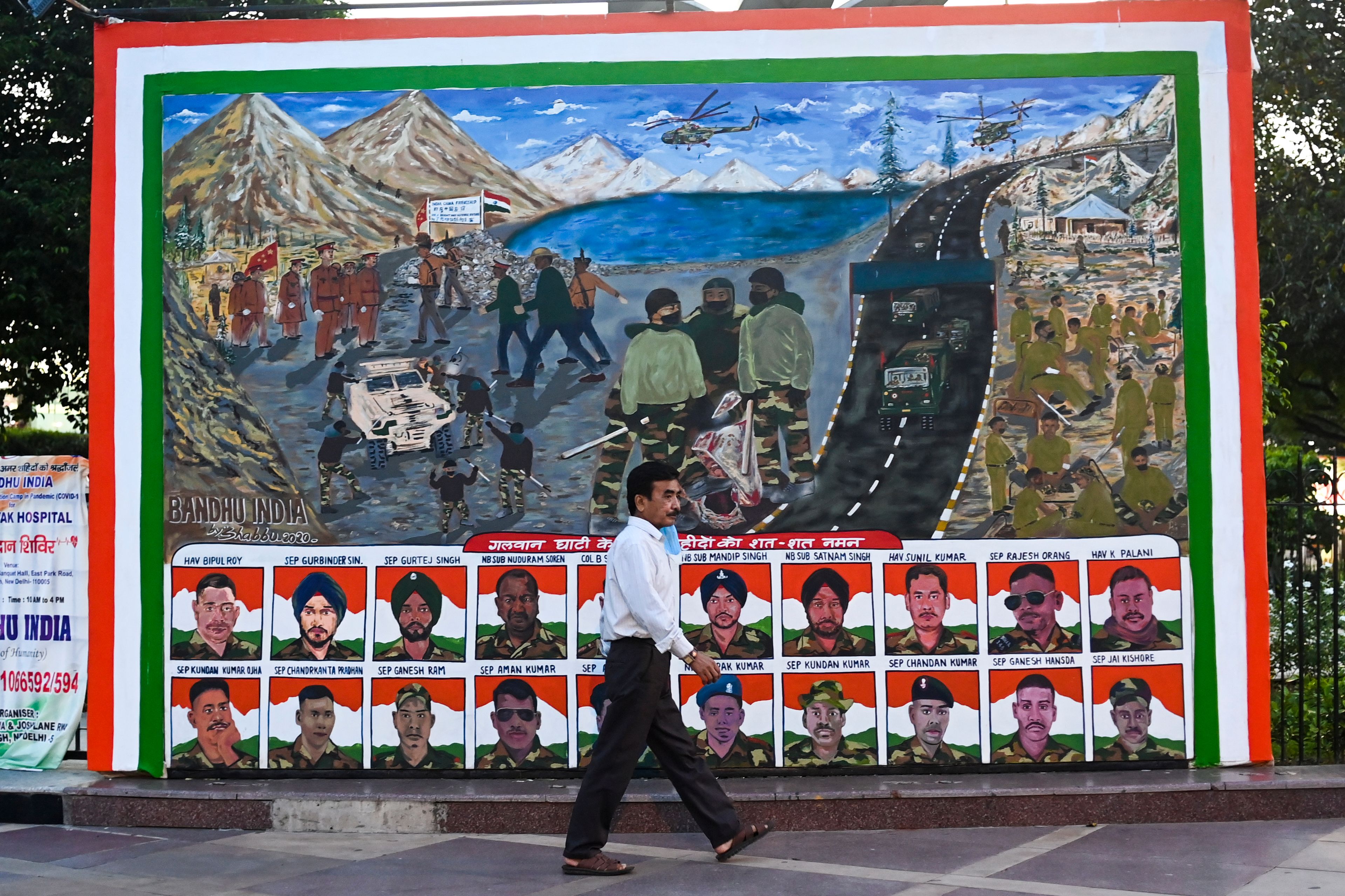 Một người đàn ông đi ngang qua một tấm áp phích, mô tả chân dung của những người lính Ấn Độ đã thiệt mạng trong cuộc chiến tay đôi với đối phương Trung Quốc của họ vào ngày 15/6, tại một khu chợ ở New Delhi vào ngày 31/8/2020. (Ảnh: Jewel Samad/AFP/Getty qua The Epoch Times)