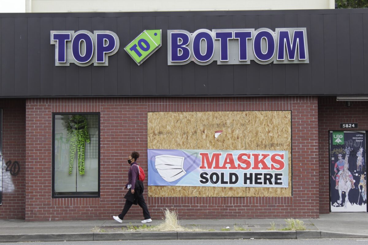 Một người đi bộ đi ngang qua một doanh nghiệp/cửa hàng bị hư hại trong cuộc bạo động gần đây, ở Portland, Ore., vào ngày 1 tháng 7 năm 2020. (Ảnh Gillian Flaccus / AP)