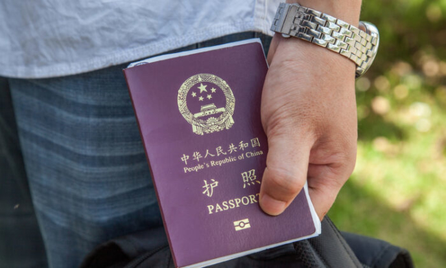 Một người Trung Quốc cầm Hộ chiếu Trung Quốc ngày 16/5/2014 (Ảnh minh họa: Omar Havana / Getty Images)