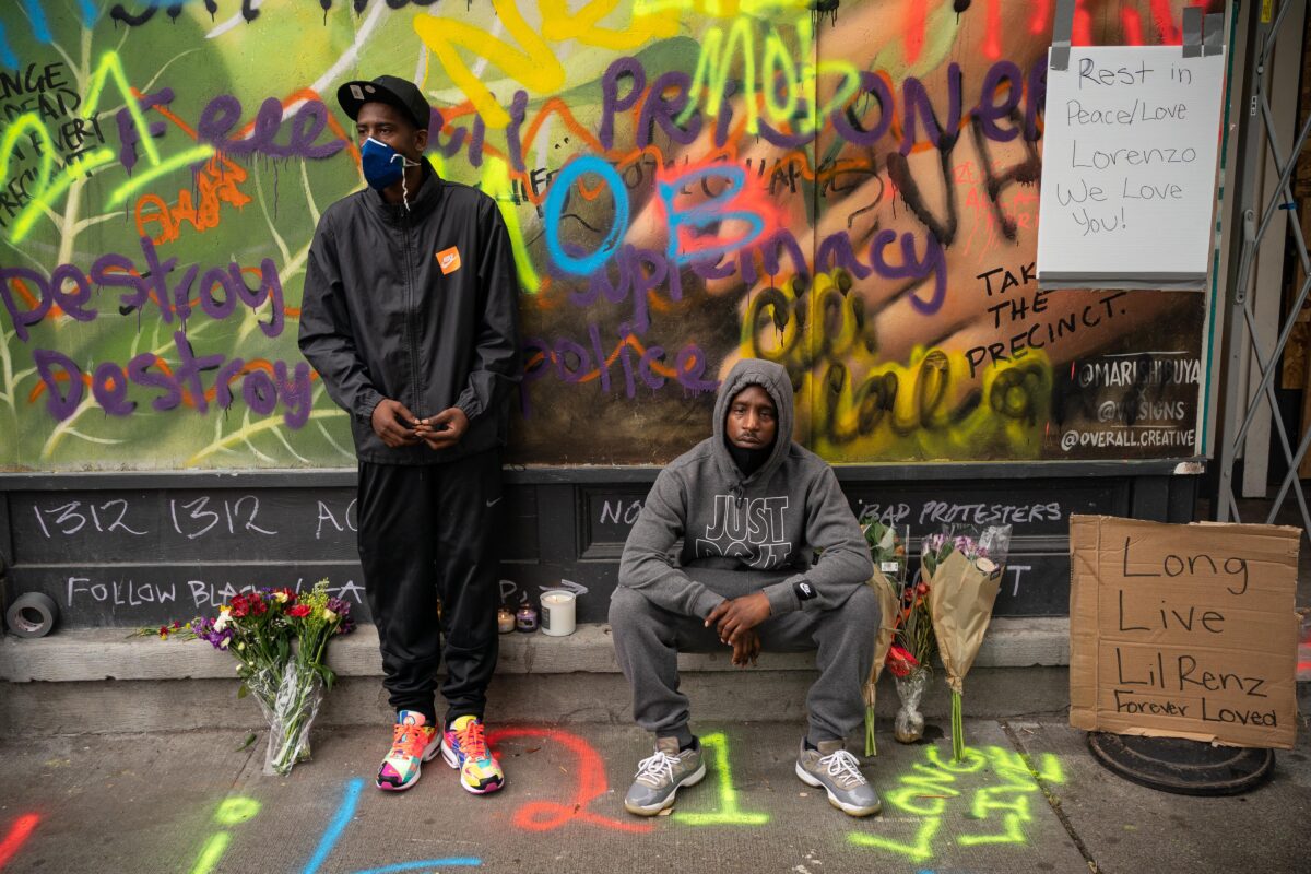 TJ Jenkins và Derel Jenkins bày tỏ lòng kính trọng của họ tại một điểm tưởng niệm gần địa điểm nơi người anh em họ của họ, Lorenzo Anderson, bị bắn chết trong khu vực được gọi là Khu tự trị Điện Capitol (CHOP) ở Seattle, vào ngày 20/6/2020. (Ảnh David Ryder / Getty Images)