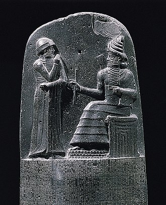 Bia đá khắc ""Bộ pháp điển Hamurabi", là cảnh Thần Thái Dương Shamash (Thần Công Lý) của Babylon đang truyền thụ pháp luật cho vua Hamurabi. (Ảnh <a href="https://vi.wikipedia.org/wiki/B%E1%BB%99_lu%E1%BA%ADt_Hammurabi">wikipedia</a>)