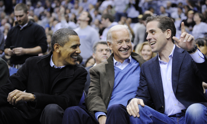 Tổng thống Barack Obama, trái, nói chuyện với Phó Tổng thống Joe Biden, ở giữa và con trai ông Hunter Biden, phải, tại trận đấu bóng rổ của trường đại học Duke Georgetown NCAA ở Washington vào ngày 30 tháng 1 năm 2010. (Ảnh AP / Nick Wass)