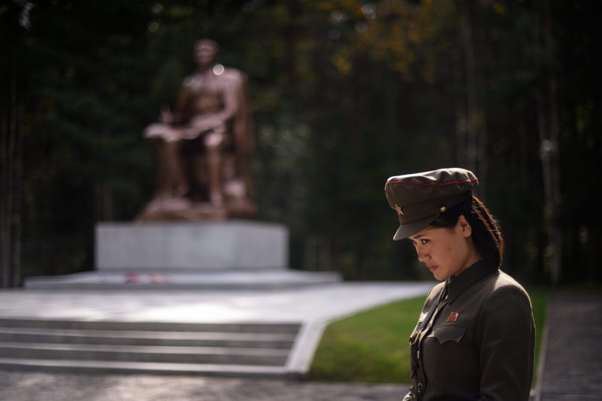 Một hướng dẫn viên đang đứng trước bức tượng của cố lãnh đạo Bắc Hàn Kim Nhật Thành tại doanh trại của một trại lính bí mật gần huyện Samjiyon, Triều Tiên vào ngày 12/9/2019. (Ảnh Ed Jone/ AFP qua Getty Images)