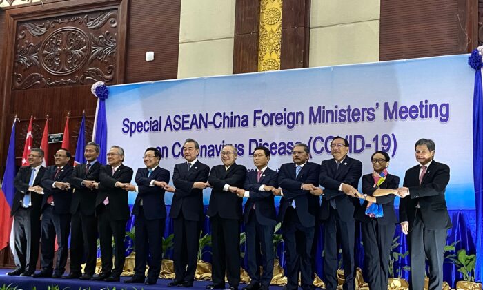 Tổng thư ký ASEAN Lim Jock Hoi và các Bộ trưởng ngoại giao bắt tay trên sân khấu tại Hội nghị Thượng đỉnh giữa Trung Quốc và ASEAN (Hiệp hội các quốc gia Đông Nam Á) về COVID-19 tại Viêng Chăn, Lào, vào ngày 20 tháng 2 năm 2020 (Ảnh Dene-Hern Chen / AFP qua Getty Images)