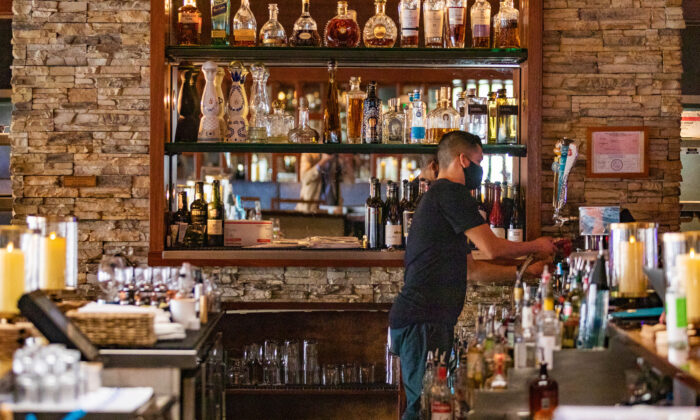 Nhân viên nhà hàng sắp xếp các đồ sau quầy bar tại một nhà hàng ở Newport Beach, California, ngày 9 tháng 9 năm 2020. (Ảnh John Fredricks / The Epoch Times)