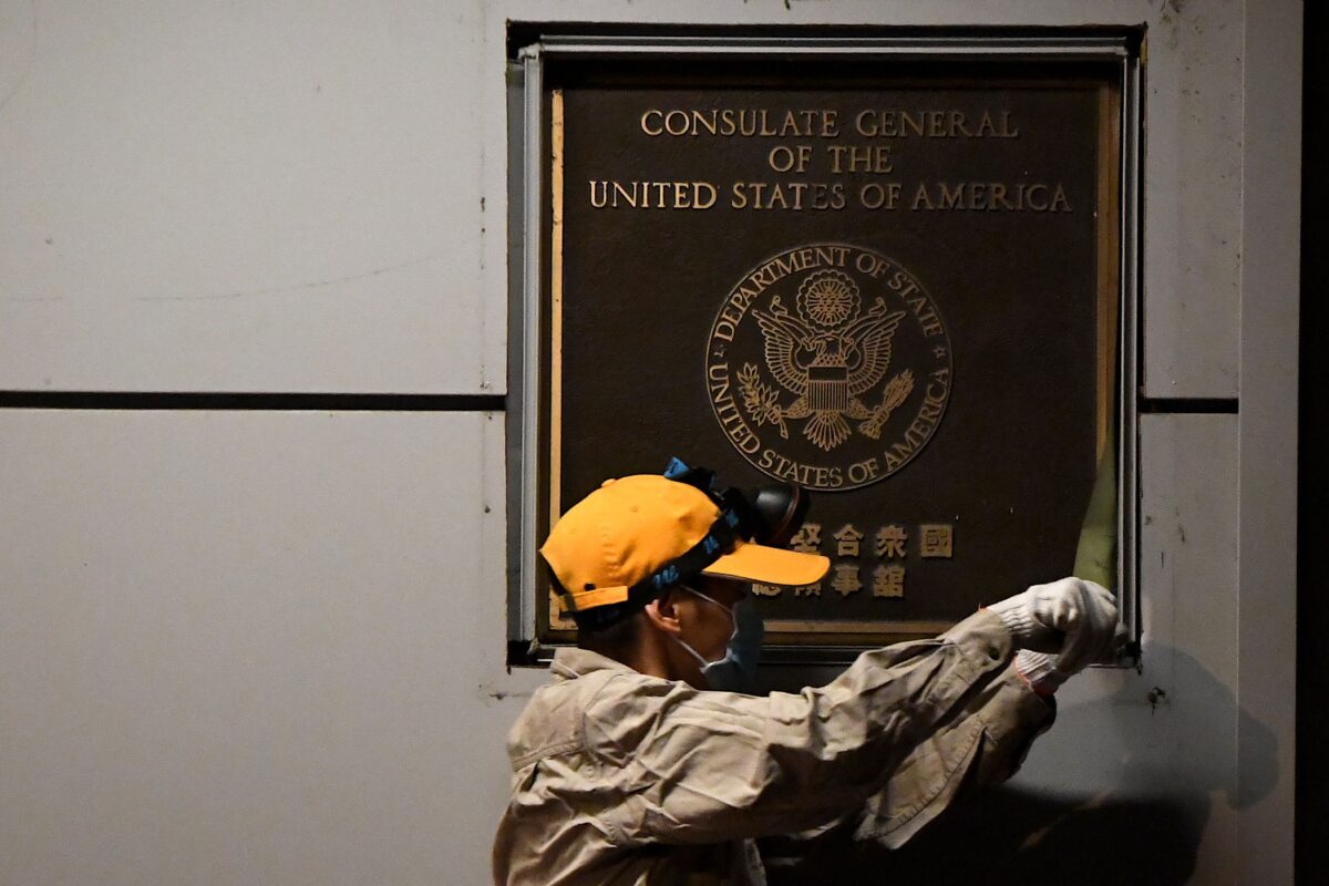 Một công nhân cố gắng tháo biển hiệu trên tường của Lãnh sự quán Hoa Kỳ ở Thành Đô, tỉnh Tứ Xuyên, tây nam Trung Quốc, vào ngày 26/7/2020. (Ảnh Noel Celis / AFP / Getty Images)
