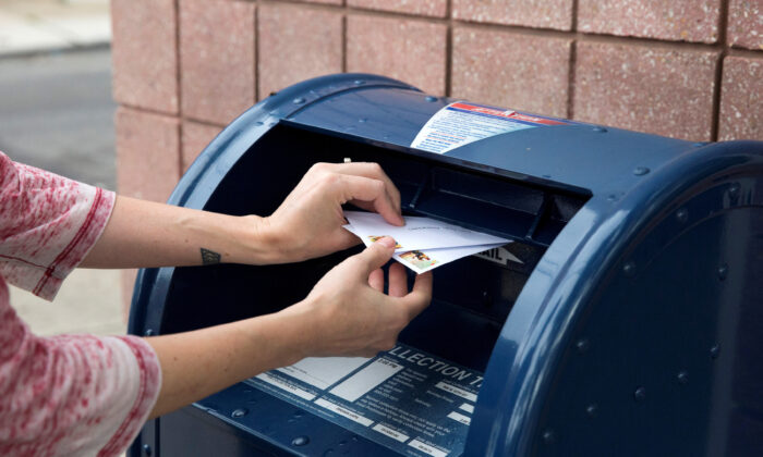 Một cá nhân gửi thư vào hộp thư thu tiền của Dịch vụ Bưu điện Hoa Kỳ ở Philadelphia, Penn., Vào ngày 14 tháng 8 năm 2020. (Ảnh Rachel Wisniewski / Reuters)