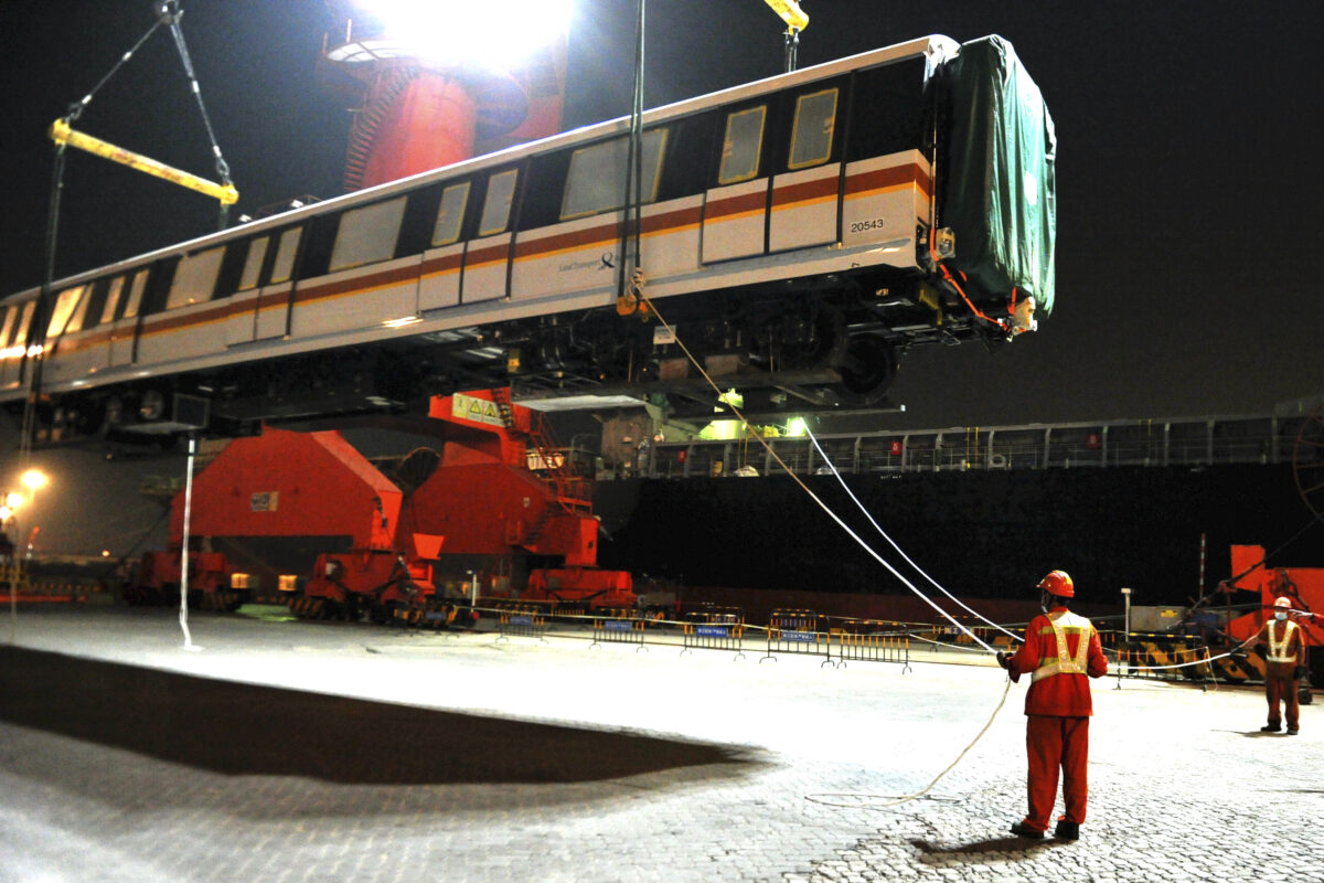 Các công nhân đang chuyển một tàu điện ngầm xuất khẩu lên một xe container tại một nhà máy đóng tàu ở Thanh Đảo thuộc tỉnh Sơn Đông, miền đông Trung Quốc vào ngày 25 tháng 9 năm 2020. (Ảnh Chinatopix / AP)