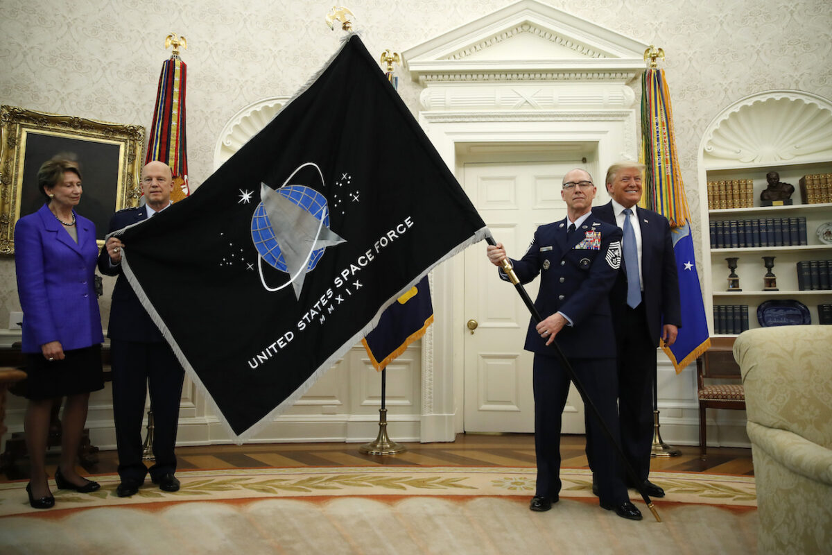 Tổng thống Donald Trump đứng bên cạnh Tư lệnh Chiến dịch Không gian Vũ trụ của Lực lượng Không gian Hoa Kỳ, Tướng John Raymond (thứ hai từ trái sang), và Đại thượng sỹ Roger Towberman (thứ hai từ phải sang) cầm lá cờ của Lực lượng Không gian Hoa Kỳ, khi nó được trưng bày trong Phòng Bầu dục của Nhà Trắng, hôm 15/5/2020 ở Washington. Bộ trưởng Không quân Barbara Barrett, đứng ngoài cùng bên trái. (Ảnh: Alex Brandon / AP)