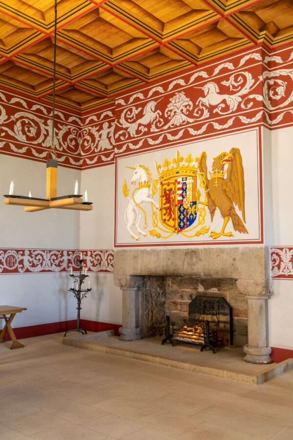 Một trong những căn phòng đã được trùng tu của cung điện hoàng gia. Trần nhà bằng gỗ, lò sưởi làm tâm điểm, dải trang trí màu đỏ và tấm thảm có hình kỳ lân và đại bàng là những đặc điểm tiêu biểu của phong cách thời Phục hưng. (Ảnh: makasana photo/Shutterstock)