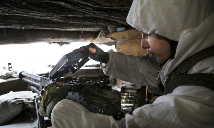 Một binh sĩ kiểm tra khẩu súng máy của mình trong một hầm trú ẩn trên lãnh thổ do các chiến binh thân Nga kiểm soát ở chiến tuyến với quân chính phủ Ukraine ở Slavyanoserbsk, vùng Luhansk, miền đông Ukraine, hôm 25/01/2022 (Ảnh: Alexei Alexandrov/AP Photo)