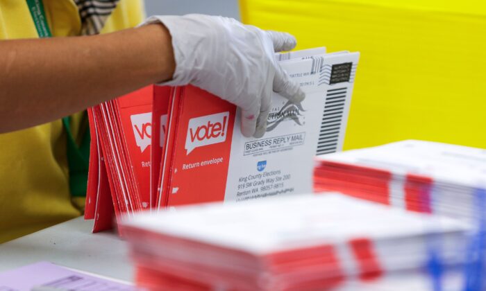 Một nhân viên bầu cử mở các bì thư chứa phiếu bầu qua thư trong một bức ảnh tư liệu. (Ảnh: Jason Redmond/AFP qua Getty Images)