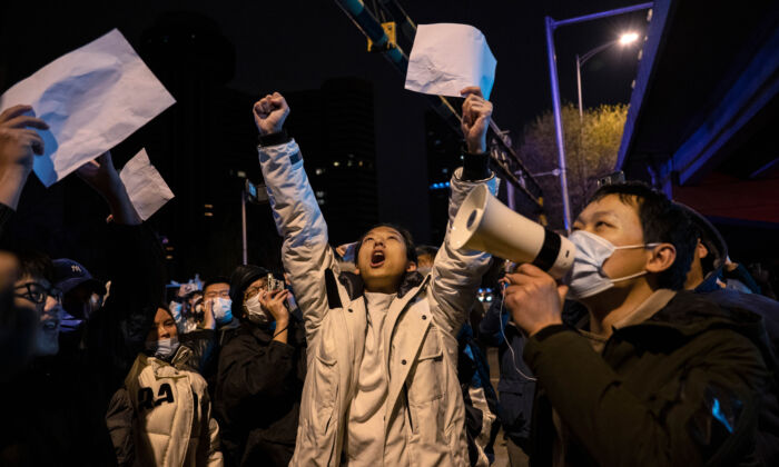Người biểu tình hô vang các khẩu hiệu trong cuộc biểu tình phản đối các biện pháp nghiêm ngặt zero-COVID của Trung Quốc ở Bắc Kinh hôm 28/11/2022. (Ảnh: Kevin Frayer/Getty Images)