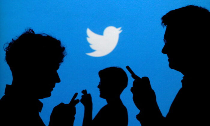 Những người dùng điện thoại di động in bóng trên phông nền có logo Twitter trong bức ảnh minh họa này được chụp vào ngày 27/09/2013. (Ảnh: Kacper Pempel/Illustration/Reuters)