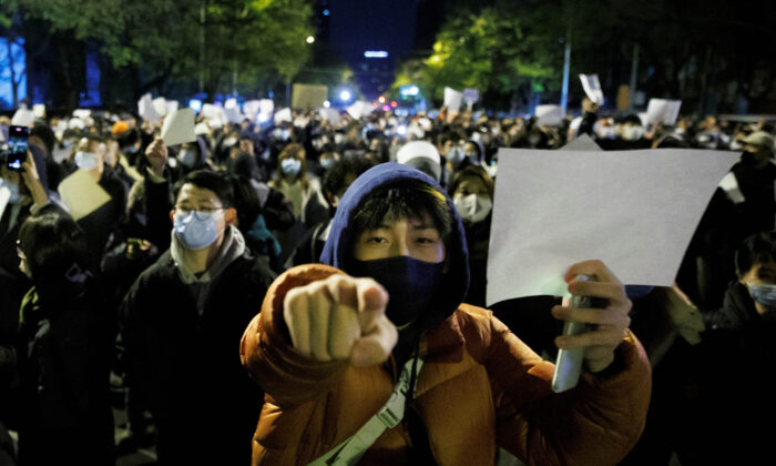 Mọi người cầm những tờ giấy trắng trong một cuộc biểu tình ở Bắc Kinh hôm 27/11/2022. (Ảnh: Thomas Peter/Reuters)