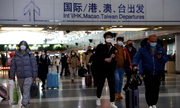 Các du khách xách hành lý đi bộ tại Phi trường Quốc tế Thủ đô Bắc Kinh, trong bối cảnh dịch COVID-19 bùng phát ở Bắc Kinh, Trung Quốc, hôm 27/12/2022. (Ảnh: Tingshu Wang/Reuters)