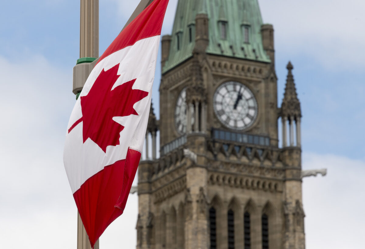 Quốc kỳ Canada treo trên một cột đèn trên con đường phía trước tòa nhà Quốc hội ở Ottawa trước Ngày Quốc khánh Canada vào ngày 30/06/2020. (Ảnh: The Canadian Press/Adrian Wyld)