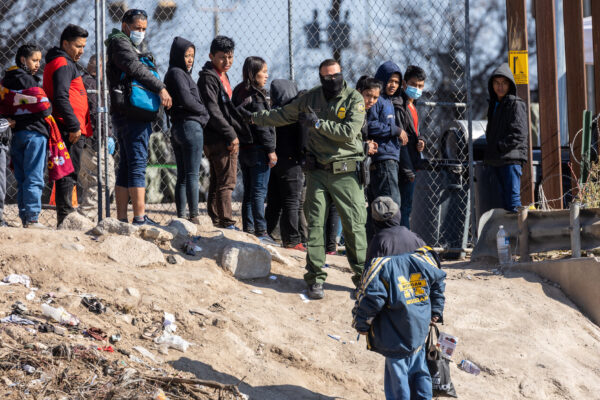 Một nhân viên Tuần tra Biên giới Hoa Kỳ hướng dẫn những người nhập cư đã vượt qua sông Rio Grande vào El Paso, Texas, hôm 19/12/2022 khi nhìn từ Ciudad Juarez, Mexico. (Ảnh: John Moore/Getty Images)