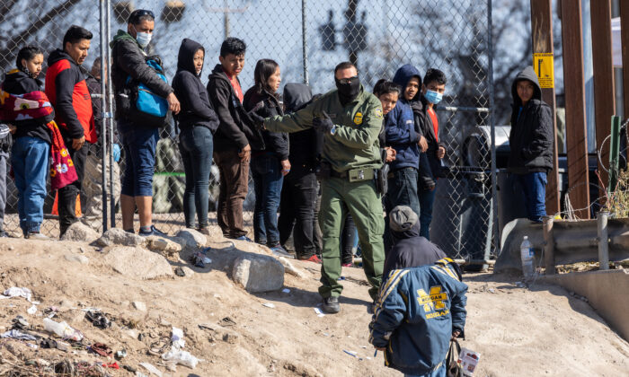 Một nhân viên Tuần tra Biên giới Hoa Kỳ hướng dẫn những người nhập cư đã vượt qua Rio Grande vào El Paso, Texas, hôm 19/12/2022 khi nhìn từ Ciudad Juarez, Mexico. (Ảnh: John Moore/Getty Images)
