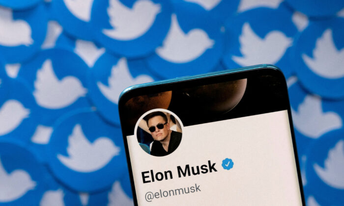 Trang cá nhân Twitter của ông Elon Musk trên một chiếc điện thoại thông minh được đặt trên những tấm logo Twitter in sẵn hôm 28/04/2022. (Ảnh: Dado Ruvic/Illustration/Reuters)