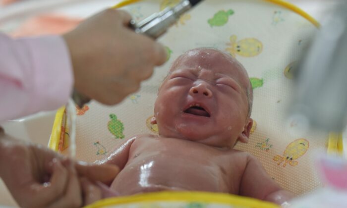 Bức ảnh được chụp vào ngày 19/01/2019 này cho thấy một nhân viên y tế đang chăm sóc một em bé mới sinh tại một bệnh viện ở thành phố Phụ Dương thuộc tỉnh An Huy miền đông Trung Quốc. - Các chuyên gia cho biết, năm ngoái (2021), dân số Trung Quốc sụt giảm lần đầu tiên sau 70 năm, cảnh báo về một “cuộc khủng hoảng nhân khẩu học” gây áp lực lên nền kinh tế đang suy thoái của nước này. (Ảnh: STR/AFP qua Getty Images)