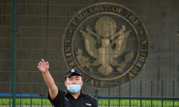 Một nhân viên bảo vệ Trung Quốc giơ tay bên ngoài Đại sứ quán Hoa Kỳ tại Bắc Kinh vào ngày 12/09/2020. (Ảnh: Greg Baker/AFP qua Getty Images)