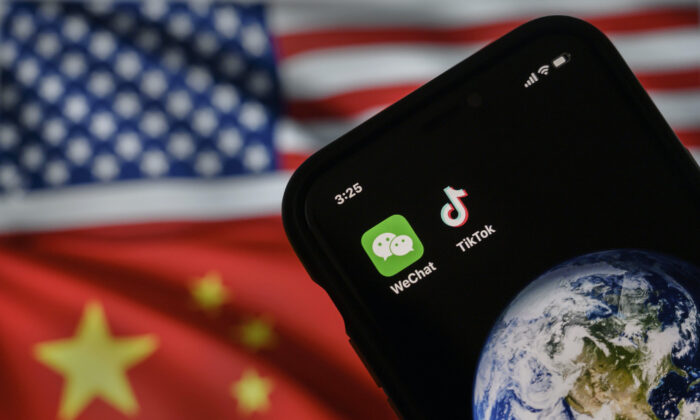 Một chiếc điện thoại di động đang hiển thị logo của các ứng dụng Trung Quốc WeChat và TikTok trước màn hình hiển thị lá cờ của Hoa Kỳ và Trung Quốc trên một trang web trên internet, ở Bắc Kinh, hôm 22/09/2020. (Ảnh: Kevin Frayer/Getty Images)