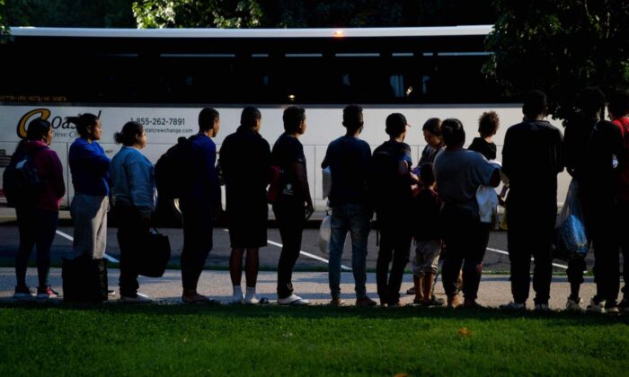 Những người di cư bất hợp pháp trên chuyến xe buýt xuất phát từ Texas đang lắng nghe các tình nguyện viên đề nghị trợ giúp sau khi được cho xuống xe, có thể được nhìn thấy từ tòa nhà Capitol Hoa Kỳ ở Hoa Thịnh Đốn hôm 11/08/2022. (Ảnh: Stefani Reynolds/AFP qua Getty Images)