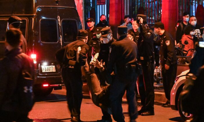Một người đàn ông bị bắt khi những người biểu tình tụ tập trên một con đường ở Thượng Hải hôm 27/11/2022. Các cuộc biểu tình phản đối chính sách ‘zero COVID’ của Trung Quốc đã diễn ra vào đêm trước đó (tức 26/11) sau một vụ hỏa hoạn tang thương ở Ô Lỗ Mộc Tề (hay Urumqi), thủ phủ của khu vực Tân Cương. (Ảnh: Hector Retamal/AFP qua Getty Images)