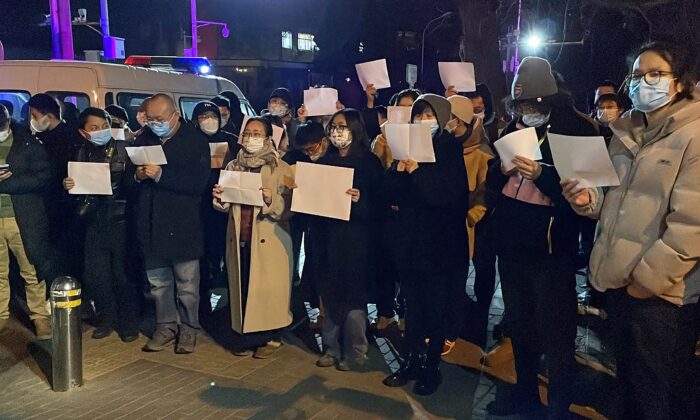 Người biểu tình tụ tập dọc một con đường trong một cuộc tập hợp vì những nạn nhân của vụ hỏa hoạn khiến nhiều người thiệt mạng cũng như cuộc biểu tình phản đối các hạn chế COVID-19 hà khắc tại Bắc Kinh, hôm 28/02/2022. (Ảnh: Michael Zhang/AFP via Getty Images)