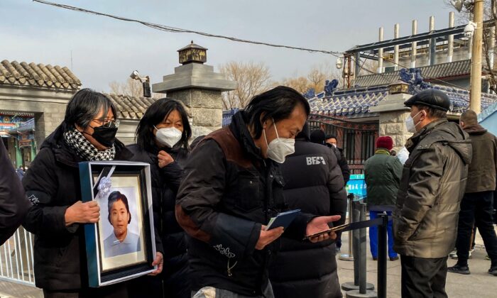 Thân nhân cầm một khung ảnh chân dung của một người thân đã qua đời tại một lò hỏa táng ở Bắc Kinh hôm 20/12/2022. (Ảnh: Noel Celis/AFP qua Getty Images)