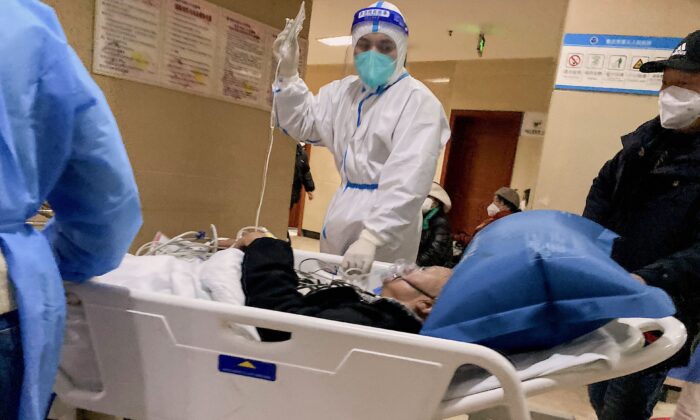 Một nhân viên y tế theo dõi tình hình của một bệnh nhân nhiễm virus corona COVID-19 trong lúc chuyển người này qua Bệnh viện Nhân dân số 5 Trùng Khánh ở thành phố Trùng Khánh phía tây nam Trung Quốc hôm 23/12/2022. (Ảnh: Noel Celis/AFP qua Getty Images)