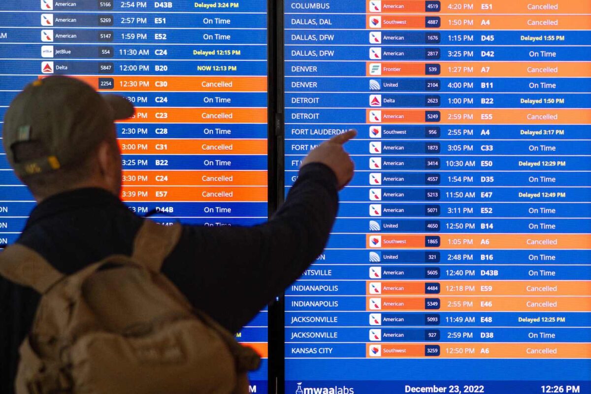 Một khách du lịch nhìn vào bảng thông tin hiển thị các chuyến bay bị hủy và hoãn tại Phi trường Quốc gia Ronald Reagan Washington trong cơn bão mùa đông trước kỳ nghỉ Giáng Sinh ở Arlington, Virginia, hôm 23/12/2022. (Ảnh: Mandel Ngan/AFP via Getty Images)
