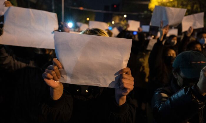 Người biểu tình giơ cao một tấm giấy trắng để tránh bị kiểm duyệt khi họ tuần hành trong cuộc biểu tình phản đối các biện pháp zero COVID nghiêm ngặt của Trung Quốc tại Bắc Kinh hôm 27/11/2022. (Ảnh: Kevin Frayer/Getty Images)
