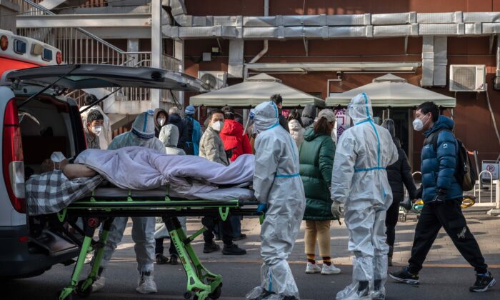 Nhân viên y tế mặc đồ bảo hộ khi họ đang khiêng một bệnh nhân nằm trên cáng tại một phòng khám sốt ở Bắc Kinh, Trung Quốc, hôm 09/12/2022. (Ảnh: Kevin Frayer/Getty Images)