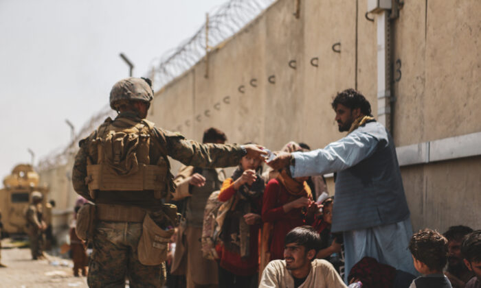 Một binh sĩ Thủy quân lục chiến Hoa Kỳ phân phát nước cho người dân trong cuộc di tản tại Phi trường Quốc tế Hamid Karzai ở Kabul, Afghanistan, ngày 21/08/2021. (Ảnh: Thủy quân lục chiến Hoa Kỳ/Isaiah Campbell/Getty Images)