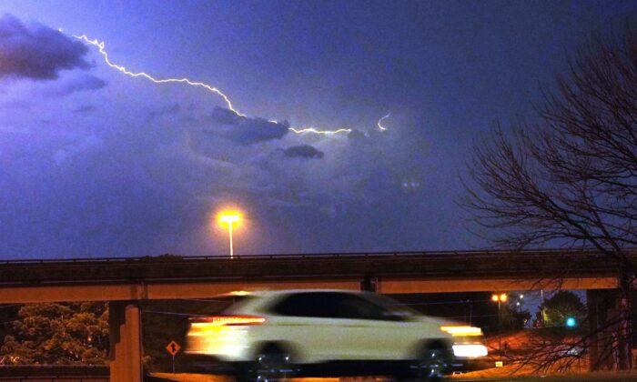Những tia sét xé ngang bầu trời khi một chiếc xe hơi chạy dọc một con đường ở Jackson, Mississippi, hôm 29/11/2022. (Ảnh: Rogelio V. Solis/AP Photo)