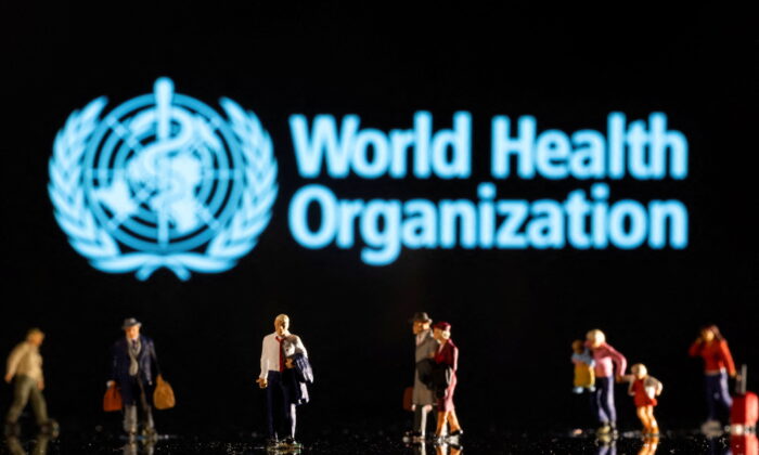 Những bức tượng nhỏ được nhìn thấy ở phía trước logo của Tổ chức Y tế Thế giới trong hình minh họa chụp ngày 11/02/2022 này. (Ảnh: Dado Ruvic/Reuters)